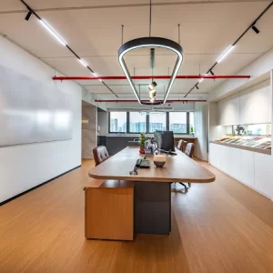 Commercial office interior design in Singapore by J Design Pte Ltd with modern lighting and collaborative meeting table.